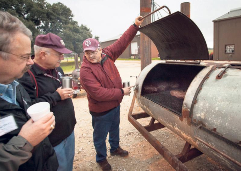 As Texas A&M professor Davey Griffin demonstrates, frequent monitoring of the smoker is part of the job. But don’t open the lid too much; that’s a no no. Camp Brisket. Michael Haskins/Special Contributor